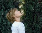 child breathing fresh air in a green space